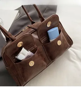 Detail of dark brown leather tote bag with two front magnetic buckle pockets for storage