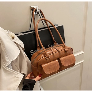 Brown vintage faux leather Boston bag with dual front pockets and cracked texture detail
