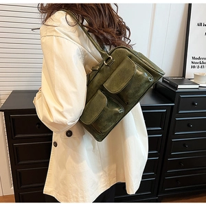 Detail shot of vintage dark green shoulder bag with two front magnetic flap pockets