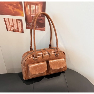 Detail of vintage brown textured leather bag with dual front pockets and double zippers