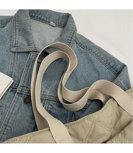Detail of beige quilted crossbody bag featuring elegant diamond stitching and wide strap