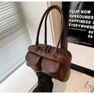 Detail of dark brown vintage faux leather shoulder bag with decorative flap pockets