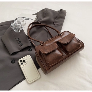 Detail of vintage dark brown tote bag featuring glossy PU leather and dual front flap pockets