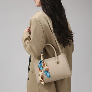 Detail of oatmeal leather tote bag with printed silk scarf wrapped around handle