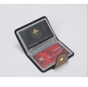 Close-up of black litchi pattern leather card holder with gold snap button and card slots