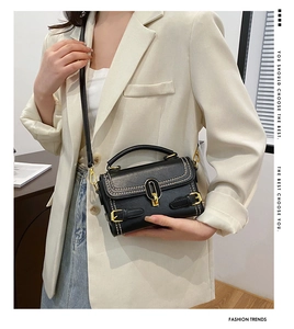 Fashionable black faux leather bag with gold buckle detail and white contrast stitching