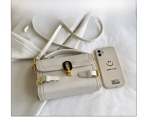 Mini cream handbag size comparison with a smartphone showing textured leather and gold clasp