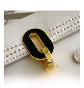 Detail of white stone-pattern leather bag featuring a gold metal clasp with black enamel