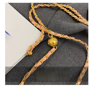 Detailed view of the pink leather woven chain strap with gold-tone ball adjustment buckle