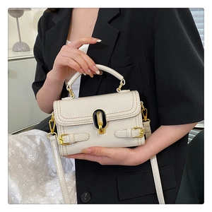 Detailed shot of white stone texture handbag featuring golden twist lock and slim shoulder strap