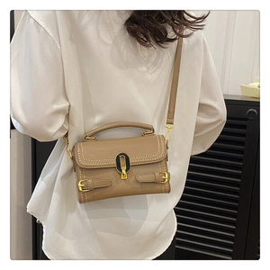 Detail shot of camel faux leather bag with contrast stitching and golden clasp