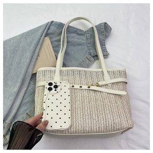 Detailed top view of beige woven tote bag with white leather straps and sizing comparison