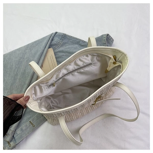 Detail of straw tote bag interior featuring smooth lining and secure zipper closure