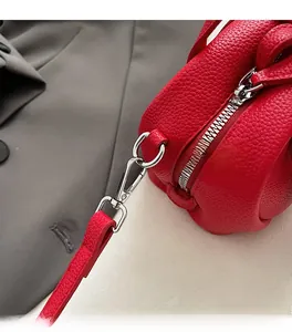 Detailed close-up of red lychee pattern leather bag with premium silver metal zipper