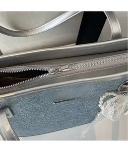 Vue détaillée de la texture du tissu métallique argenté et du zip en métal poli