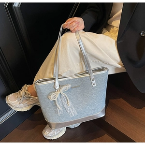Détail du grand sac cabas argenté avec texture en tissu et nœud en dentelle et perles