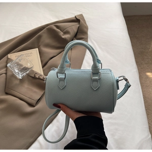 Détail du sac Boston en cuir grainé bleu clair avec finitions argentées et poignées