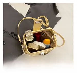 Interior view of the yellow quilted handbag showing storage for perfume and lipstick