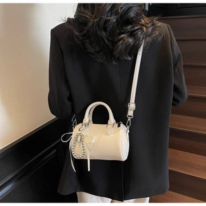Détail du mini sac Boston blanc en cuir grainé avec ruban et breloque en perles argentées