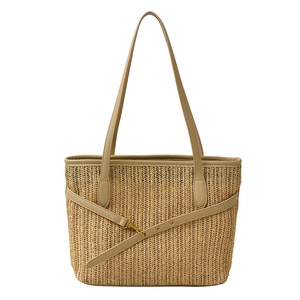 Summer straw tote bag with brown leather trim and golden buckle on white background