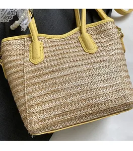Detail of woven straw texture and bright yellow leather strap on the bucket bag