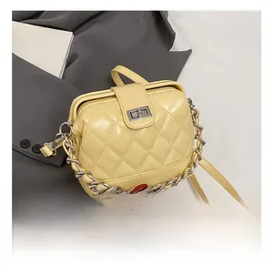 Detail of light yellow quilted handbag featuring silver metal twist lock and chain strap