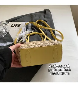 Detail view of the protective feet on the bottom of a straw bucket shoulder bag