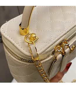 Detail of quilted leather bucket bag with gold chain strap and metal handle