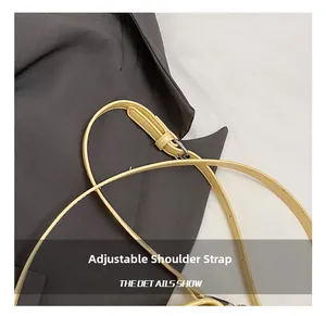 Detail of adjustable pale yellow leather shoulder strap with polished silver buckle