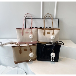 Close-up of four textured striped tote bags in various colors with cute plush charms