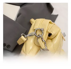 Close-up of premium silver metal hook and yellow quilted leather detail on fashion handbag