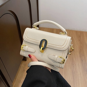 Off-white embossed stone pattern handbag with gold hardware and adjustable strap