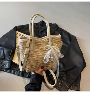 Close-up of woven straw tote bag with elegant pearl charms and white lace bow detail