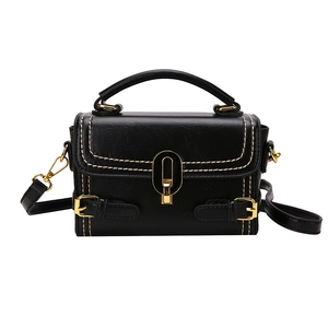Fashion black embossed crossbody bag with white stitching and gold metal turn-lock