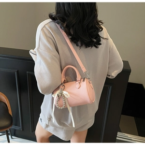 Vue détaillée du sac polochon rose à grain de litchi porté par l'arrière par une femme