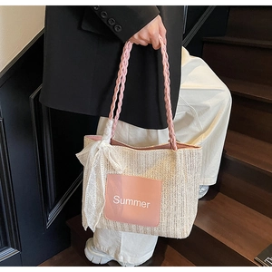 Detail of hand-woven straw tote bag with pink leather Summer patch and lace ribbon