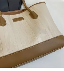 Detail view of the wave-textured tote bag with brown leather trim and neat stitching