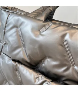 Close-up of quilted down fabric detail on a metallic silver tote bag with shiny texture