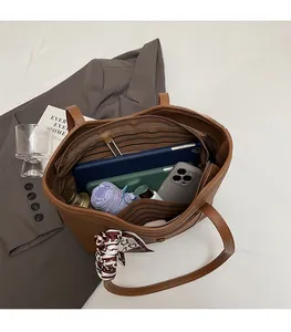 Detail of spacious tote bag interior showing capacity for tablet, umbrella and makeup