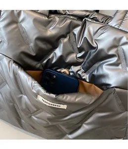 Detail of silver quilted tote bag showing brown inner pocket with large smartphone
