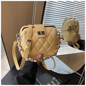Detail of yellow quilted faux leather handbag with silver lock and chain strap