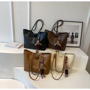 Detailed display of large faux leather tote bags in four colors with cute bunny charms