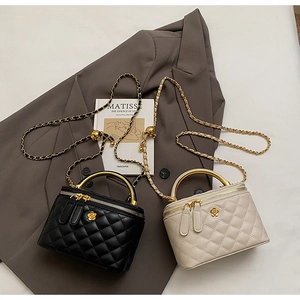 Detail of quilted leather bucket bags with gold chain straps and metal handles