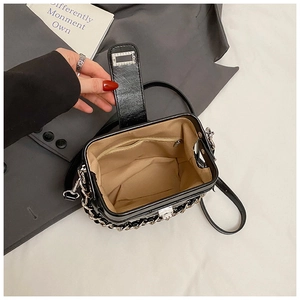 Close-up of black quilted bag interior with silver chain and secure zip pocket
