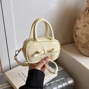 Mini yellow bow crossbody bag for kids featuring smooth leather and detachable strap