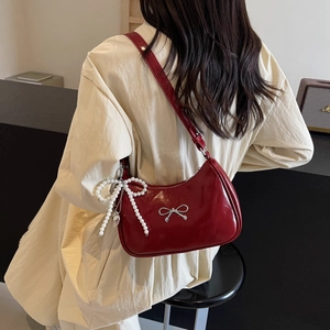 Dark red hobo bag with silver bow buckle and pearl charm shown on model