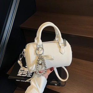 Sac polochon blanc texture litchi avec pendentif cœur et nœud élégant en soie