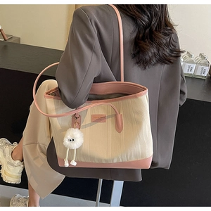 Detail of pink and white canvas tote bag with contrast leather trim and plush charm