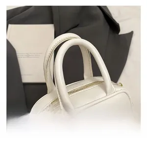 Detail showing the comfortable double round handles and white bow on a mini crossbody bag