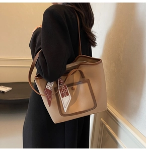 Detail of lychee pattern leather tote bag with a decorative silk scarf and side pocket